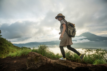 Sticker - Woman enjoying sunrise from a top of mountain Batur, Bali, Indonesia.