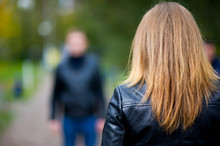 Girl In A Leather Jacket Stands With His Back To The Viewer And Meets A Man Who Is In Defocus
