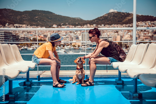 Fotografía Mother and daughter sitting on the deck of a ferry with a dog