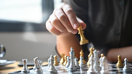 Wall Mural - Closeup hand confidently colleagues playing chess to develop analysis new strategy and decision plan.