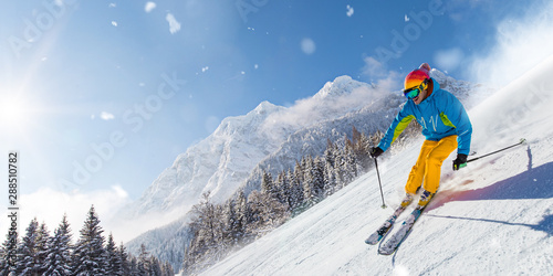 Plakaty Narciarstwo  narciarz-na-nartach-zjazd-w-sloneczny-dzien-w-wysokich-gorach