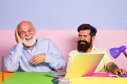 Funny Colleagues Having Fun Sitting At Desk With Laptops Excited