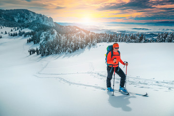 Ski touring on the snowy hills at sunset, Carpathians, Romania