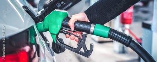 Cuadros en Lienzo Woman pumping gasoline fuel in car at gas station.