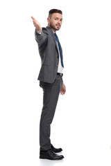 Wall Mural - side view of a young businessman pointing hand at camera