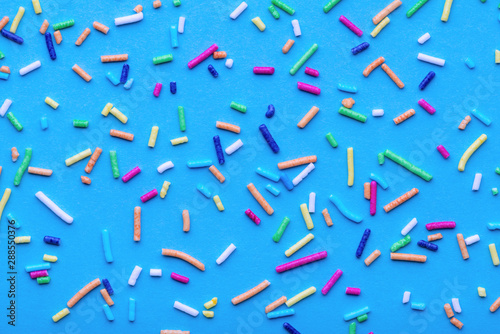 colorful various sprinkles over blue background, festive decoration for banne...