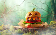 Halloween Party Burger In Shape Of Scary Pumpkin   On Natural Wooden Board. Halloween Food Concept.