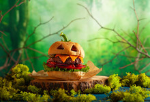 Halloween Party Burger In Shape Of Scary Pumpkin  On  Wooden Board. Halloween Food Concept.