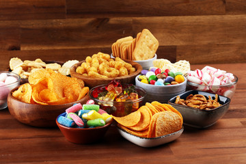 Wall Mural - Salty snacks. Pretzels, chips, crackers and candy sweets on table