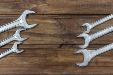 set of wrenches on a wooden background, place for an inscription