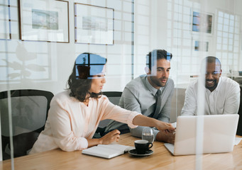 Wall Mural - Diverse businesspeople working on a laptop inside of an office