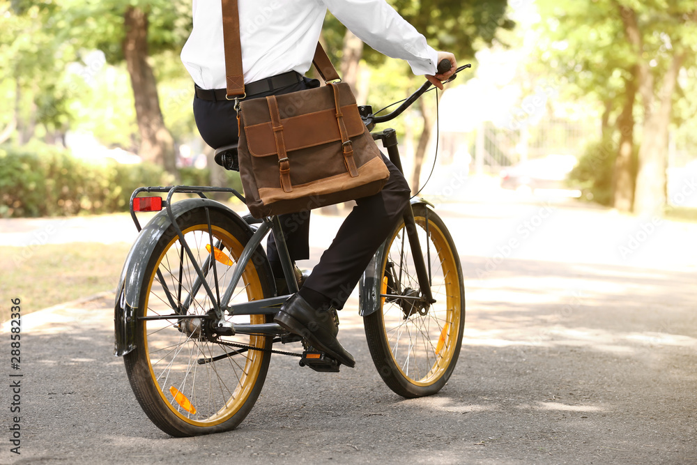 Young businessman riding bicycle outdoors