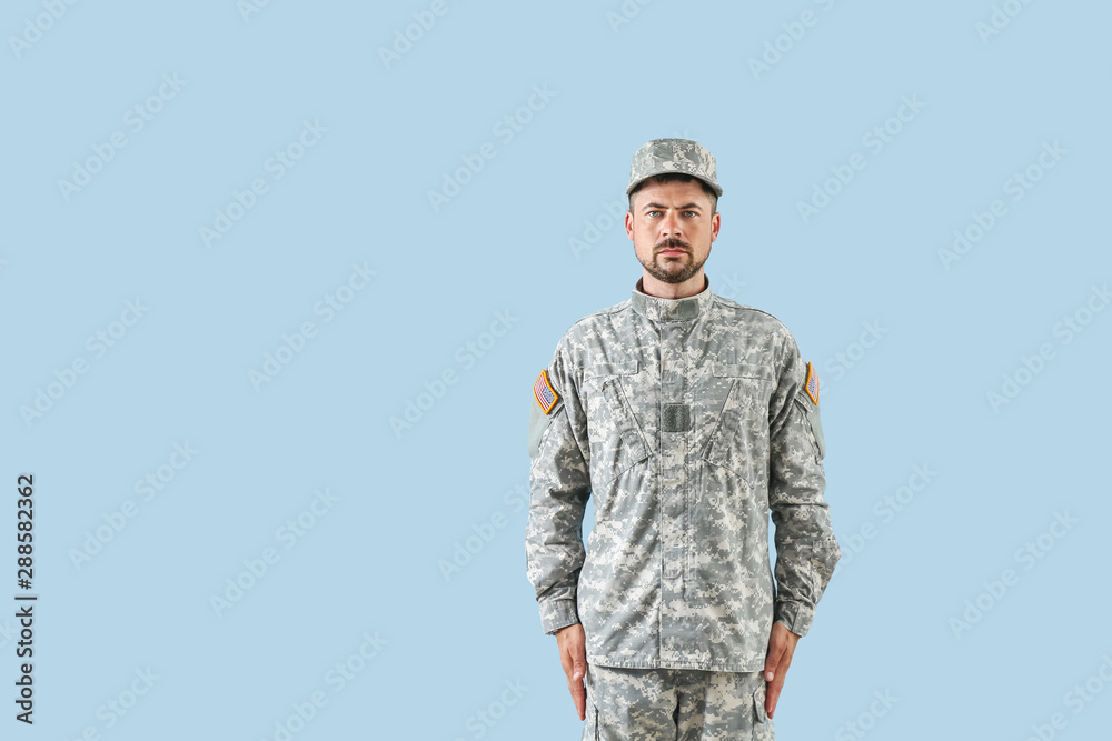 Soldier in camouflage on color background