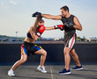 © Xalanx - Young woman boxer hitting pads outdoor
