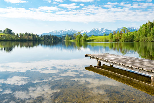 Holzsteg führt in einen Bergsee hinein