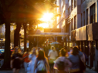 Wall Mural - Crowds of diverse people walking down the sidewalks of 14th Street with the bright light of summer sunset shining above in New York City