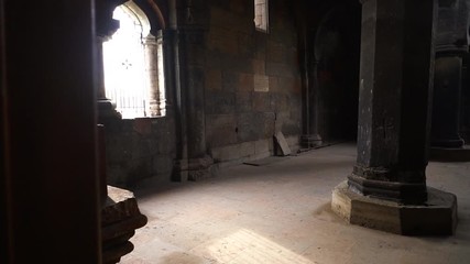 Wall Mural - walking through the doorway into the Interior of an old european church with sunlight shining through ornate windows onto a central pillar
