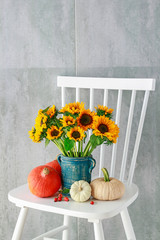 Fotomurales - Bouquet of sunflowers and colorful pumpkins on white wooden chair.