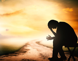 Wall Mural - Grieving depression concept: Silhouette human sitting on the way over spiritual sunset background