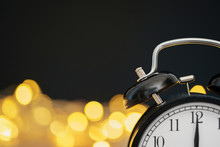 Close Up Of Retro Alarm Clock On Blurred Christmas Background With Bokeh