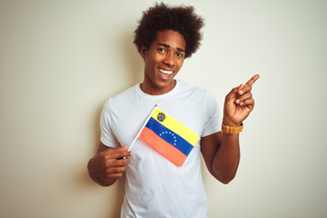 afro american man holding venezuela venezuelan flag standing over isolated white background very hap