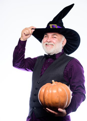 Wall Mural - making jack o lantern. mature man magician in witch hat. bearded man ready for halloween party. evil wizard hold orange pumpkin. Stargazer in holiday costume. Traditional food. happy halloween