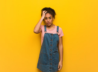 Wall Mural - Young black african american girl with blue eyes tired and very sleepy