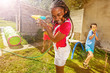 Girl with group of kids play water pistol fight
