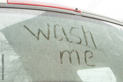 Fotografía Write the words wash me on the very dirty surface of the car