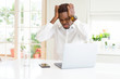 © Krakenimages.com - African american business man working using laptop suffering from headache desperate and stressed because pain and migraine. Hands on head.