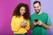© Drobot Dean - Portrait of young caucasian couple man and woman in colorful clothing smiling and holding cellphones together