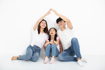 happy young family sitting on floor with home concept