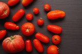 Fototapeta Kuchnia - Organic long tomatoes on black background