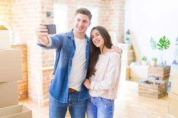 Poster - Beautiful young couple smiling happy taking a selfie photo with smartphone, very excited moving to a new home