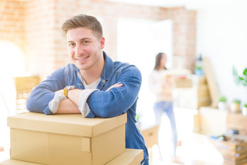 Poster - Beautiful young couple moving to a new home, young man smiling happy to the camera excited for new apartment