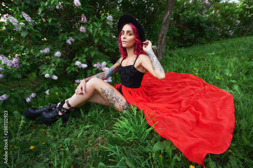 Fashion Girl With Bright Red Dyed Hair In Apple And Lilac Flowers
