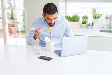 Wall Mural - Business man eating asian food from delivery while working using computer laptop at the office