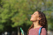 © Antonioguillem - Happy mixed race student breathing fresh air in a park
