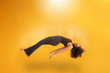 Side view of afro hair woman in zero gravity or being abducted by a UFO. Girl is flying or floating in the air. Side view of person. Over yellow background. Spiritism. Rising to the heaven.