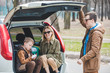 © phpetrunina14 - young family packing for car travel. putting bags into trunk