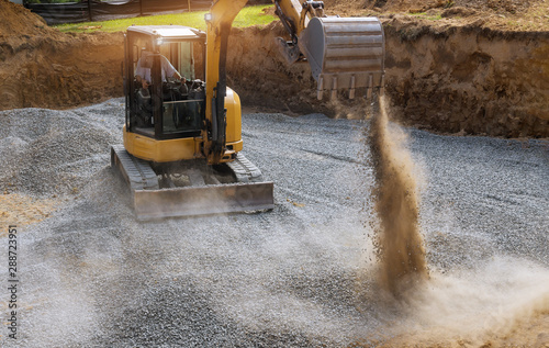 Cuadros en Lienzo Excavator bucket moving gravel stones for foundation building