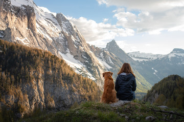 girl with a dog in the mountains. Autumn mood. Traveling with a pet. Nova Scotia Duck Tolling Retriever