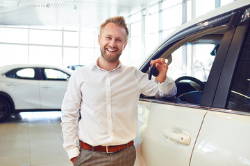 Canvas Print - Happy buyer of a new car holds keys