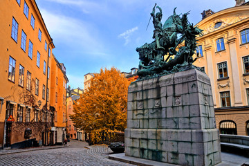 Canvas Print - Saint George and the Dragon statue and colorful street during autumn in Gamla Stan, the Old Town of Stockholm, Sweden