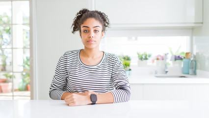 Canvas Print - Beautiful african american woman with afro hair wearing casual striped sweater Relaxed with serious expression on face. Simple and natural looking at the camera.