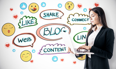 Poster - Blogging concept with woman using laptop at hand drawn words and social icons background.
