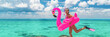 Happy fun beach vacation woman tourist ready to jump in ocean swimming with snorkel fins and pink flamingo toy pool float. Goofy swimmer girl running on holidays panoramic banner.