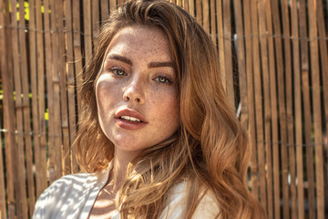 Wall Mural - Portrait of young redhead woman with freckles.