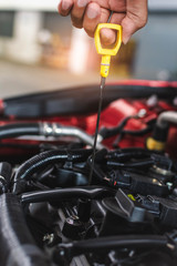 Man service mechanic maintenance inspection service maintenance car Check engine oil level car in garage showroom dealership blurred background.