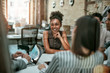 © Kostiantyn - We are one team! Young and cheerful afro american woman smiling while having a meeting with colleagues in the modern office